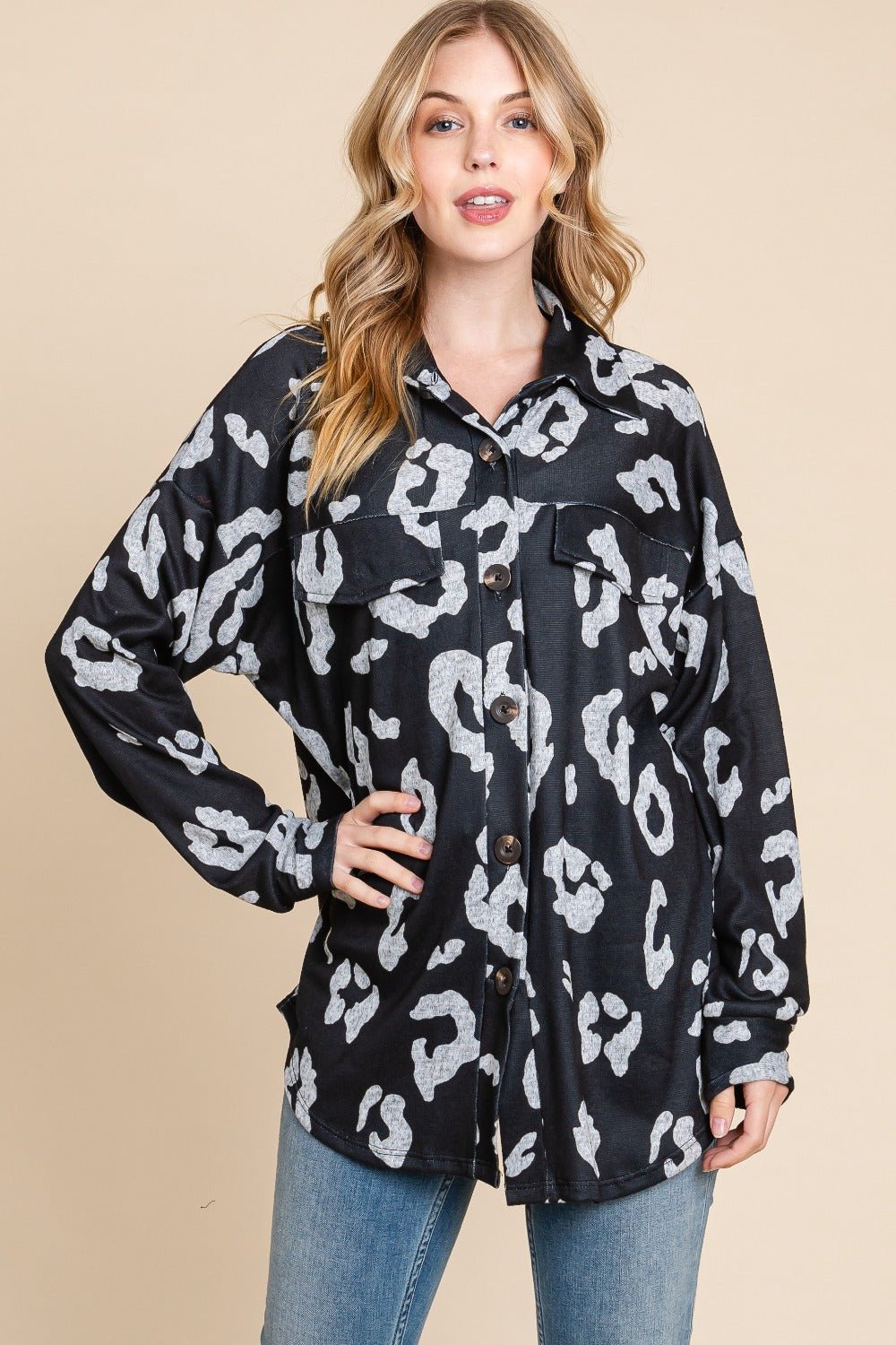 Woman wearing animal print button-up knit shacket with pockets, slightly stretchy fabric, polyester blend.