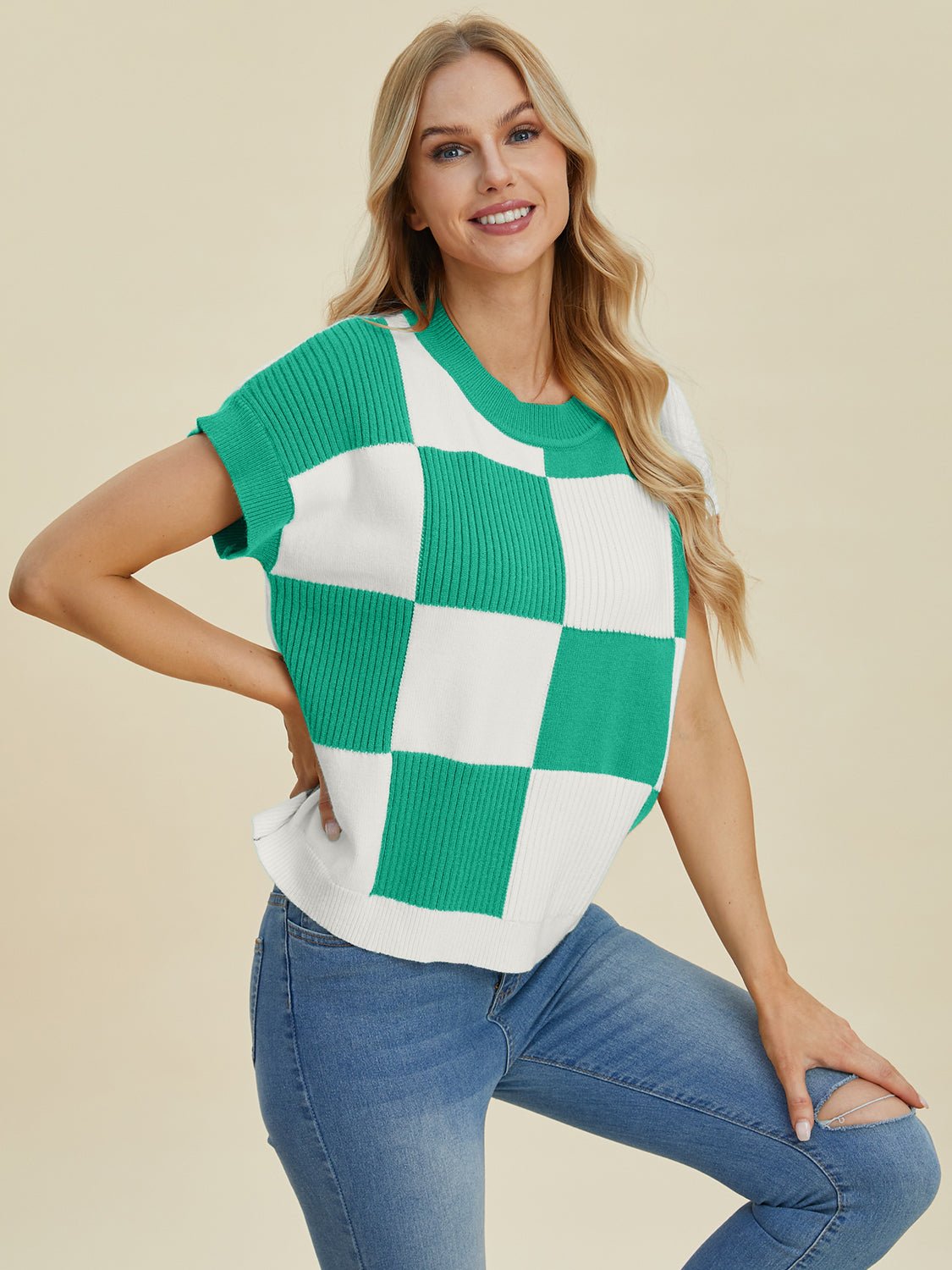 Woman wearing green and white checkered round neck short sleeve sweater with jeans, featuring a slightly stretchy material composition.