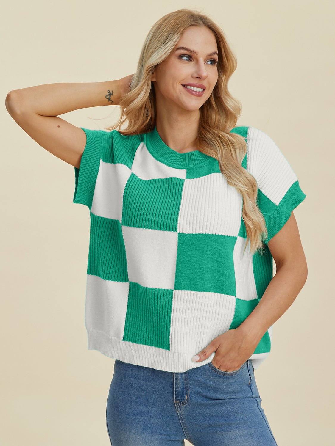 Woman wearing a green and white checkered round neck short sleeve sweater, made of viscose, polyester, and polyamide.