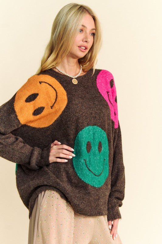 Woman wearing contrast smile round neck oversize sweater with colorful smiley faces, made of acrylic, polyester, and spandex.