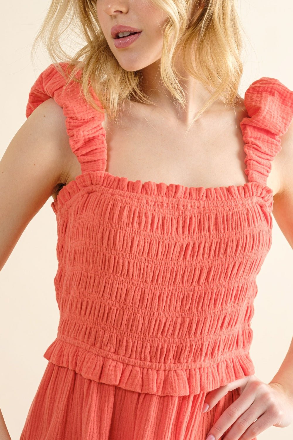 Coral smocked ruffled tiered dress in 100% cotton, featuring ruched details and frill straps, no stretch fabric.