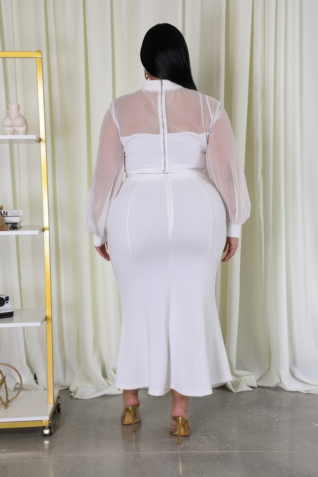 Woman in white Curvy Glam Stretch Skirt Set with mesh accents and high-waisted skirt, showcasing the back design and zipper closure.