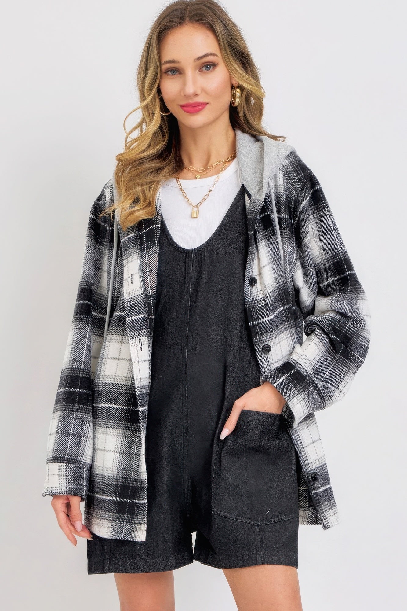 Woman wearing black denim romper with plaid jacket, casual style