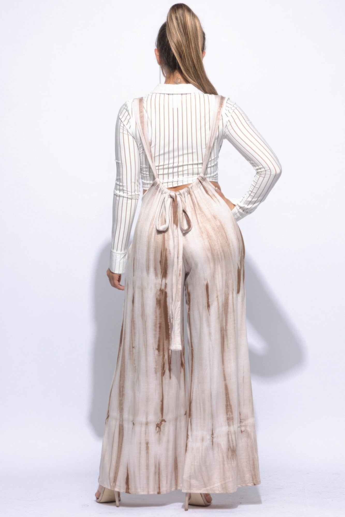 Woman wearing a mocha tie-dye drawstring baggy jumpsuit with a wide silhouette, showcasing trendy style and comfort.