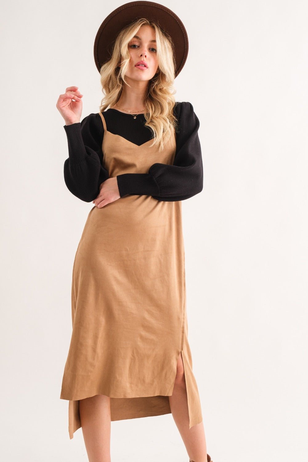 Woman wearing a faux suede cut edge slit cami midi dress with a high-low hem and black top, featuring a stylish hat.