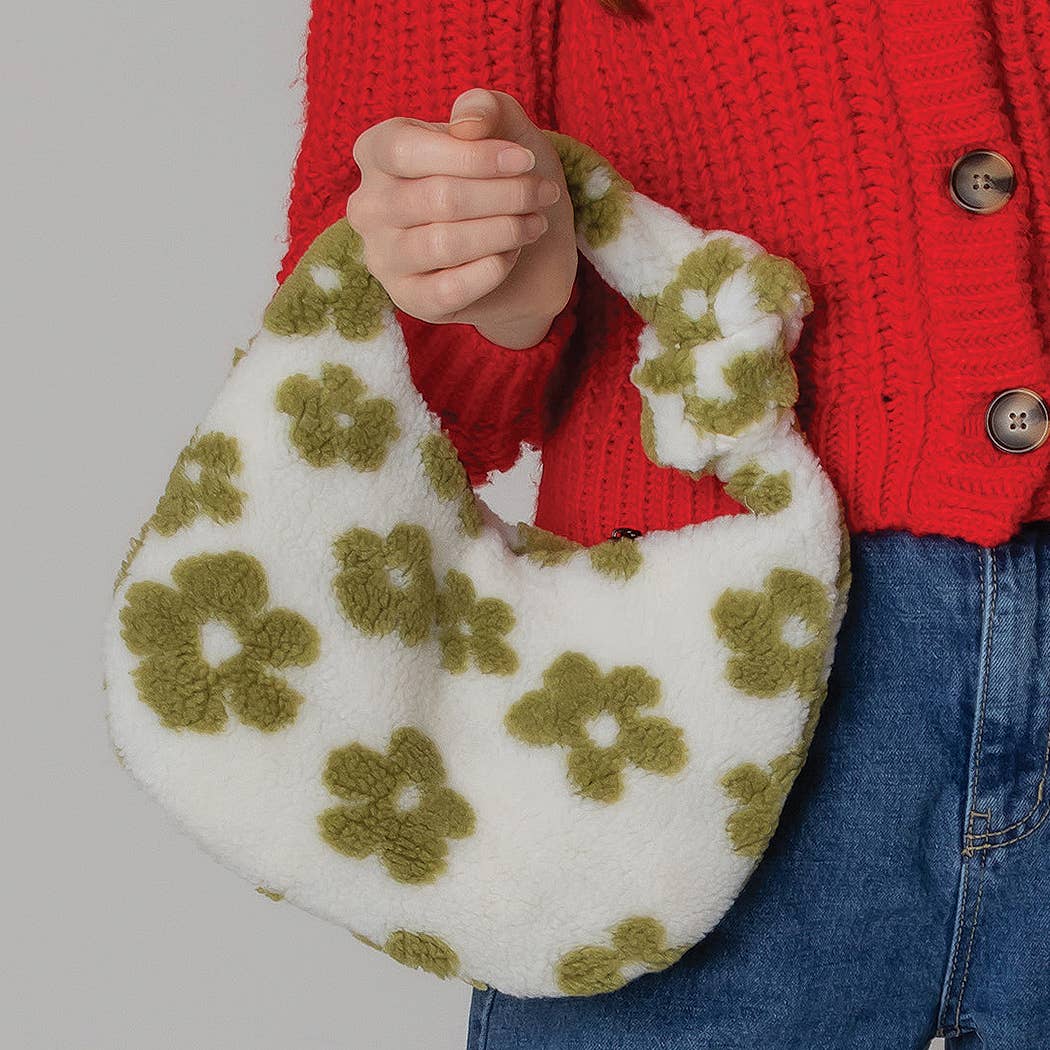 Floral Pattern Sherpa Bag in green and white held by a person in a red sweater and blue jeans, ideal for fall and winter fashion.