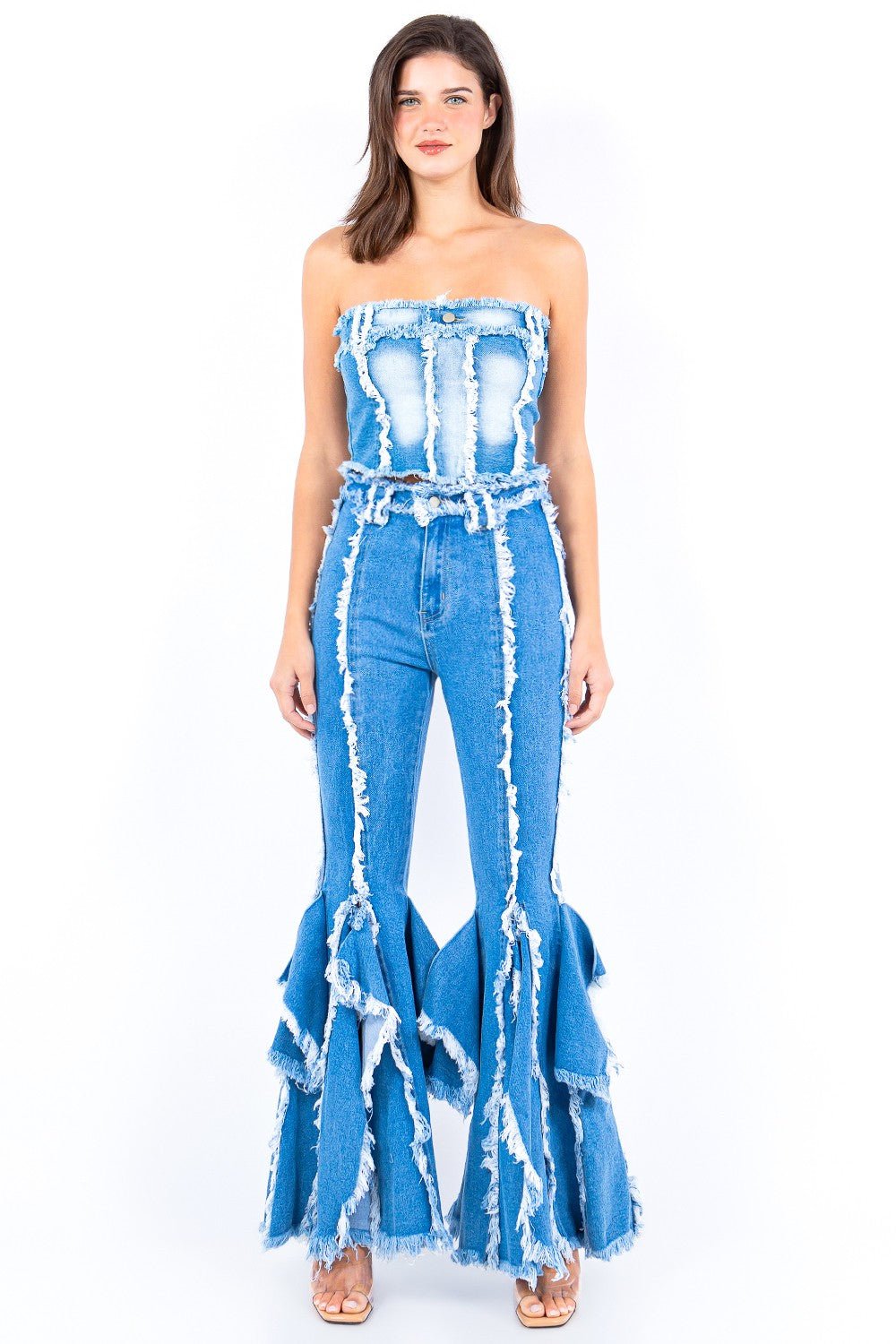 Woman wearing a frayed edge denim corset top with matching high-waisted flare jeans, featuring an edgy and stylish raw hem design.