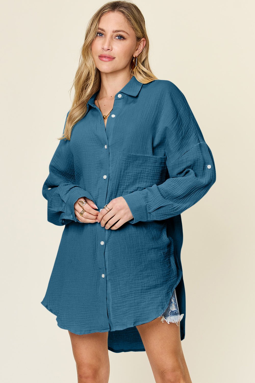 Woman wearing a full-size pocketed texture button-up shirt in teal, showcasing front view with long sleeves and casual style.
