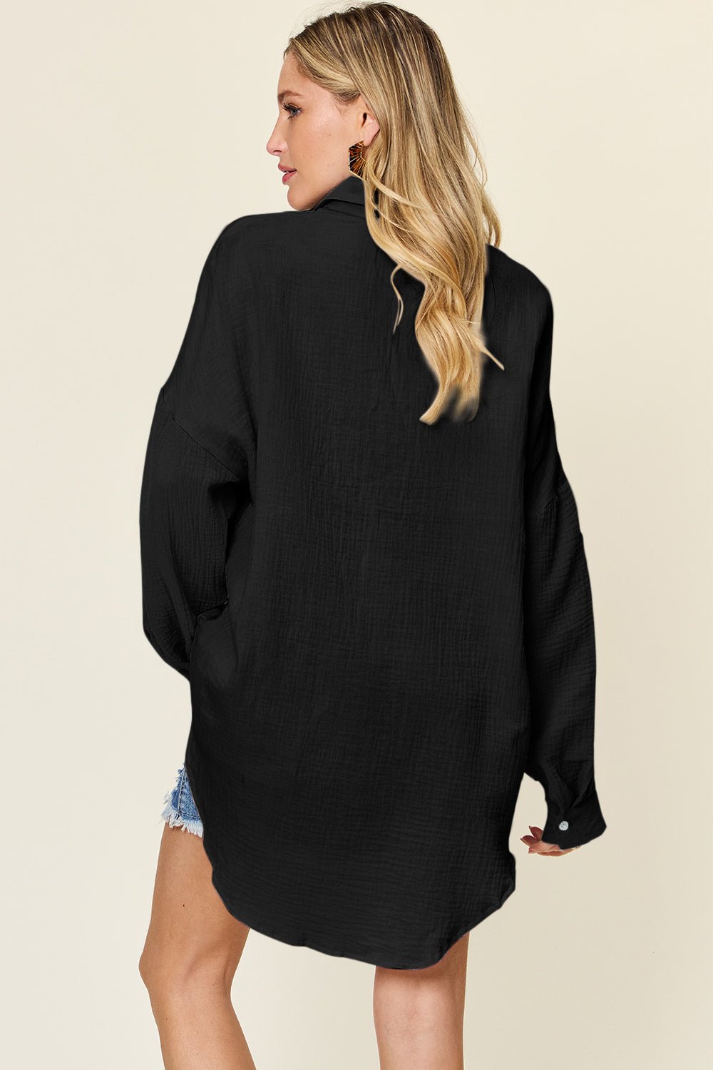Woman wearing a full-size black pocketed texture button-up shirt made of slightly stretchy 100% cotton.