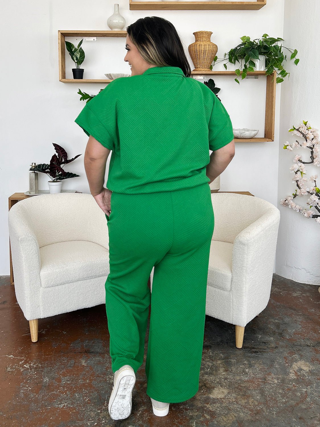 Green two-piece half zip short sleeve top and pants set with pockets, featuring a slightly stretchy fabric, showcased from the back.