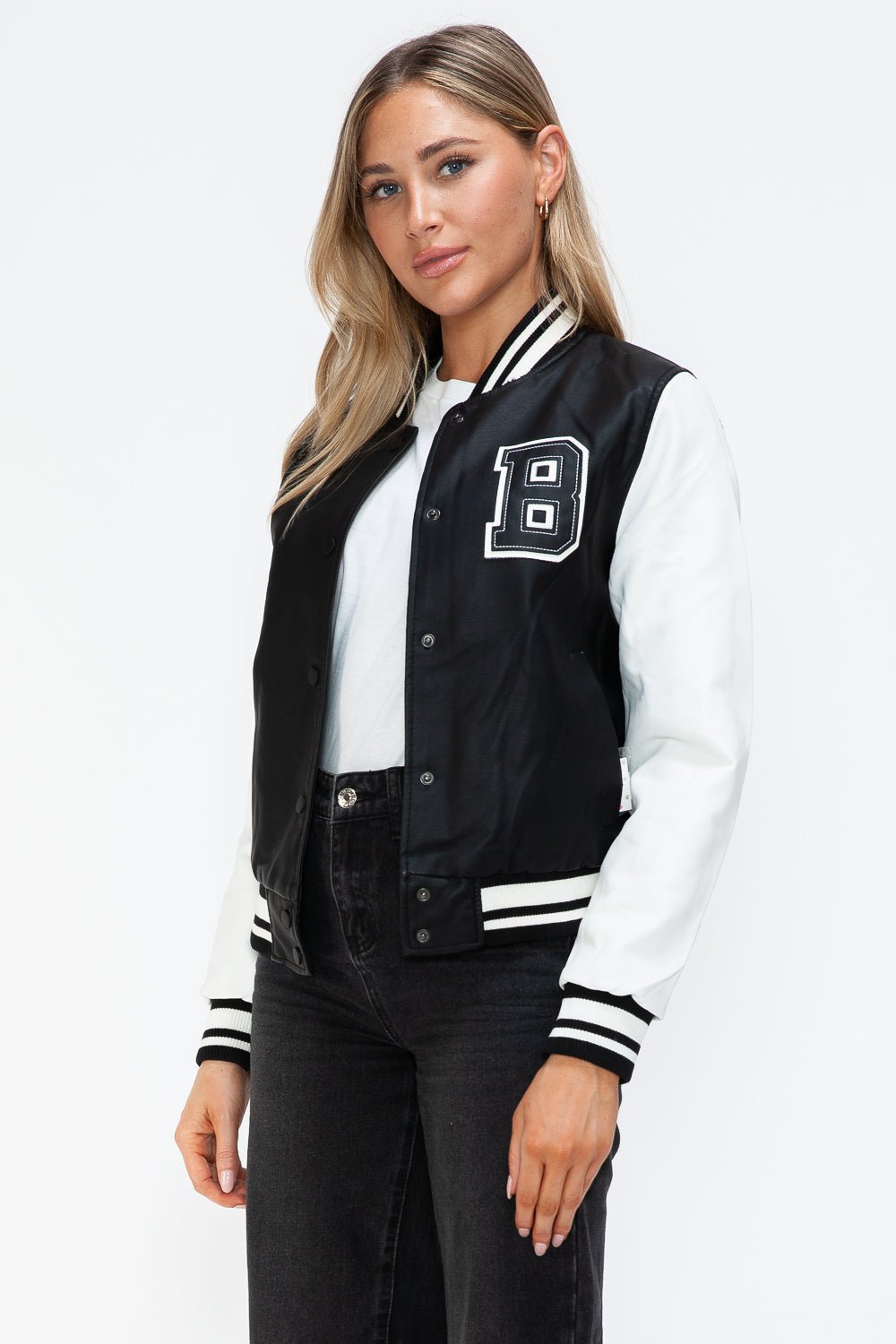 Woman wearing a Love PU Leather Contrast Snap Down Bomber Jacket with black and white design and letter embellishment.