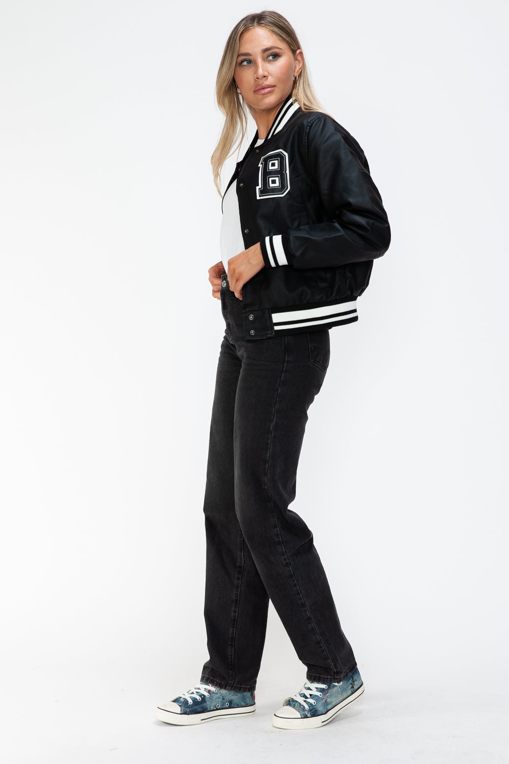 Woman wearing Midnight Black PU Leather Bomber Jacket with contrast snap down and striped cuffs.