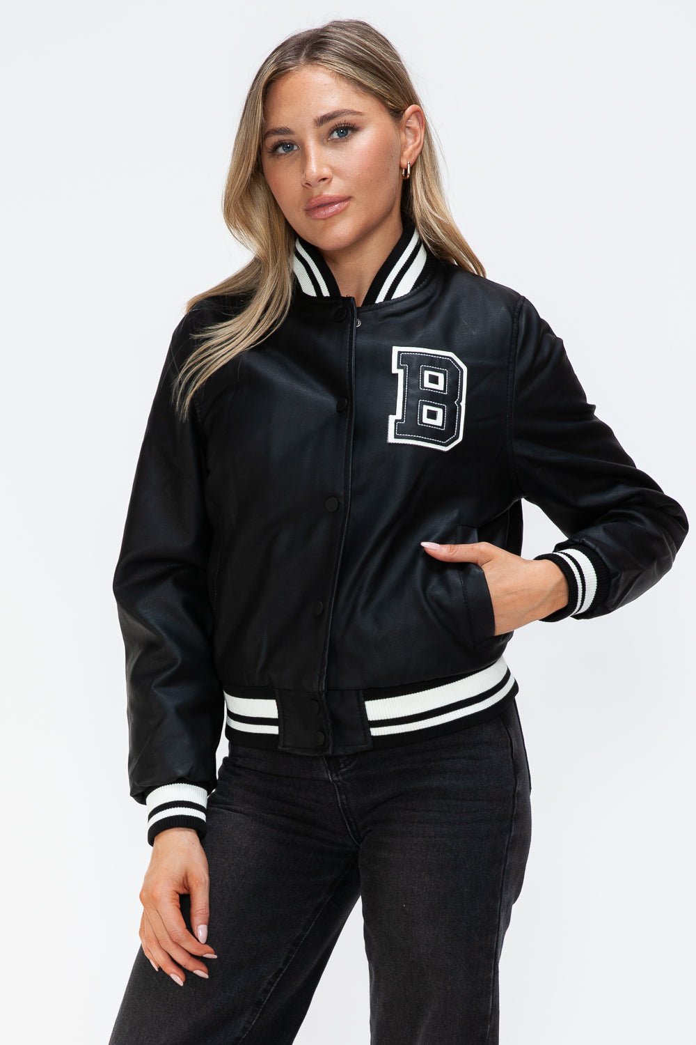 Woman wearing a Midnight Black PU Leather Contrast Snap Down Bomber Jacket with letter "B" patch and striped cuffs.