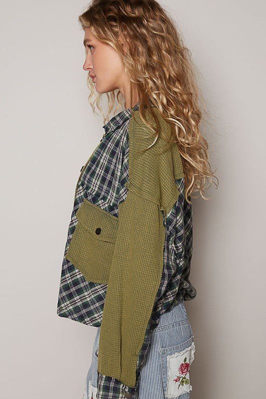 Woman wearing olive plaid button down shirt with chest pockets and waffle-knit texture, side view.