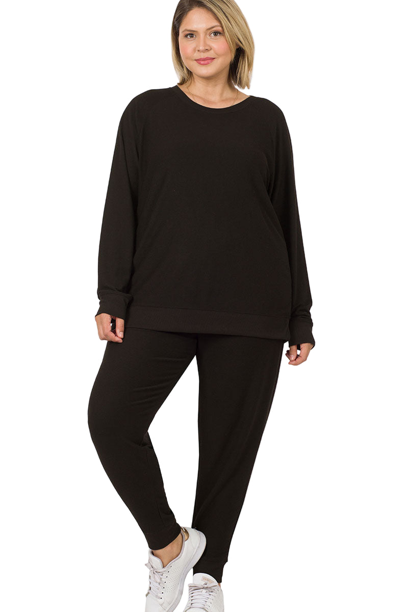 Plus size reverse soft French terry top and jogger pants set in black, featuring cozy fabric and a relaxed fit, styled with sneakers.