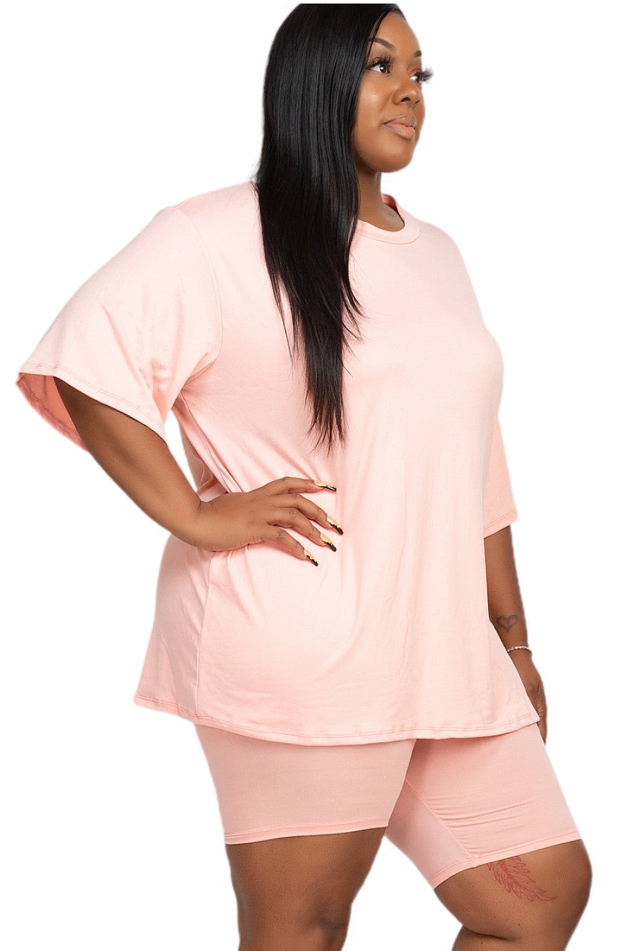 Plus size woman in pink loose fit top and biker shorts set, comfortable casual tracksuit for women, lightweight and breathable fabric