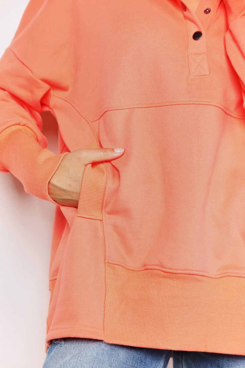 Casual solid quarter-snap dropped shoulder hoodie with pocket in coral, showcasing long sleeves and buttoned neckline.