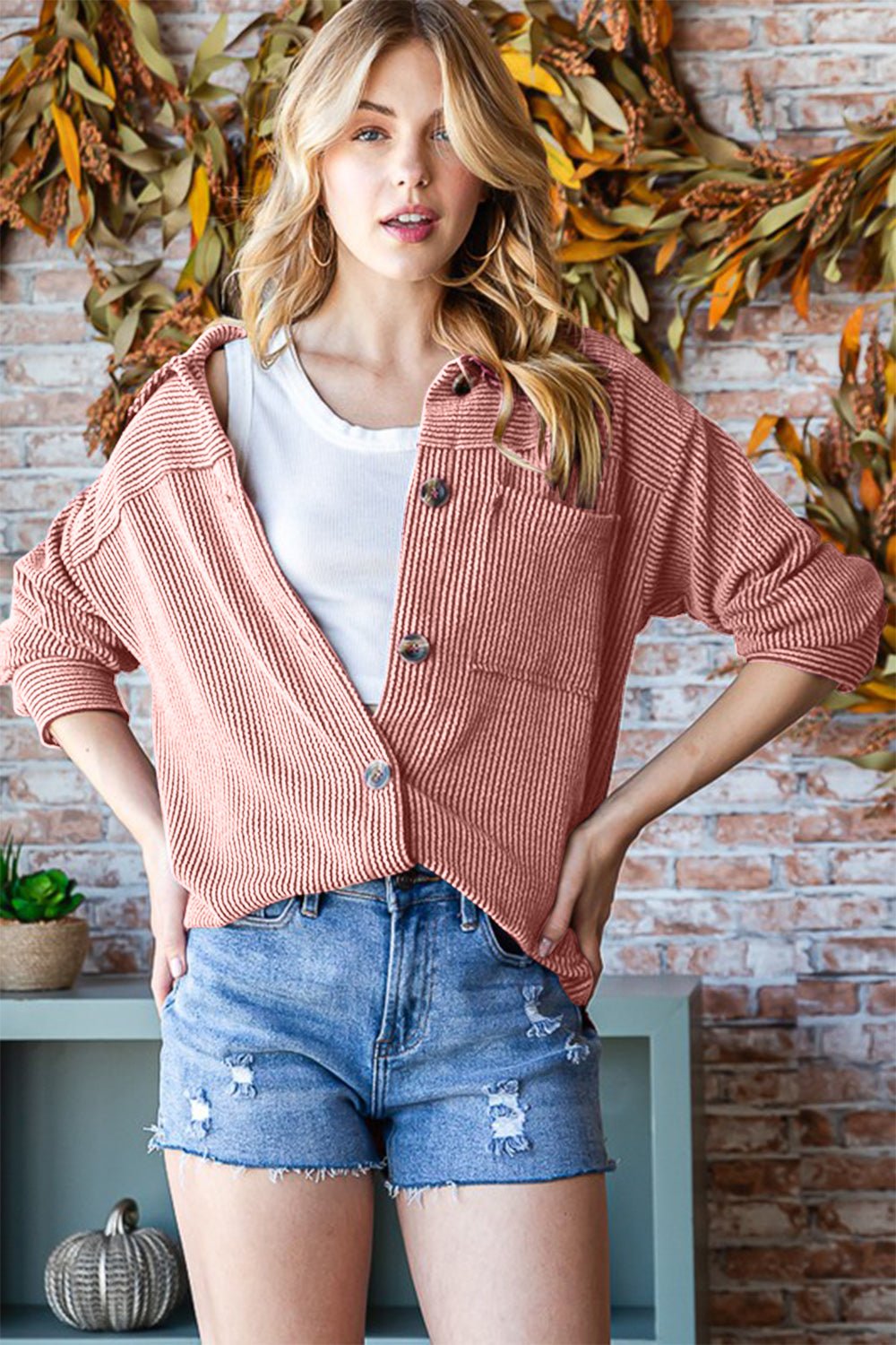 Woman wearing a Reborn J Button Up Long Sleeve Shacket with casual denim shorts, featuring a cozy fall setting.