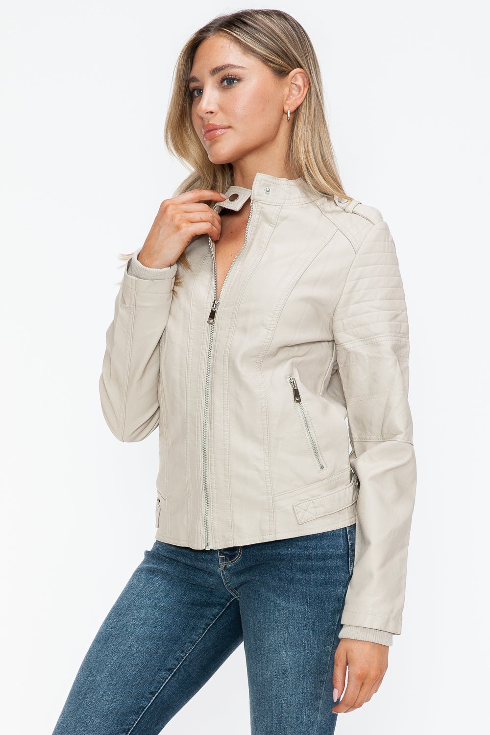 Woman wearing sand-colored PU leather biker jacket with side zip pockets, showing off basic style and normal thickness.