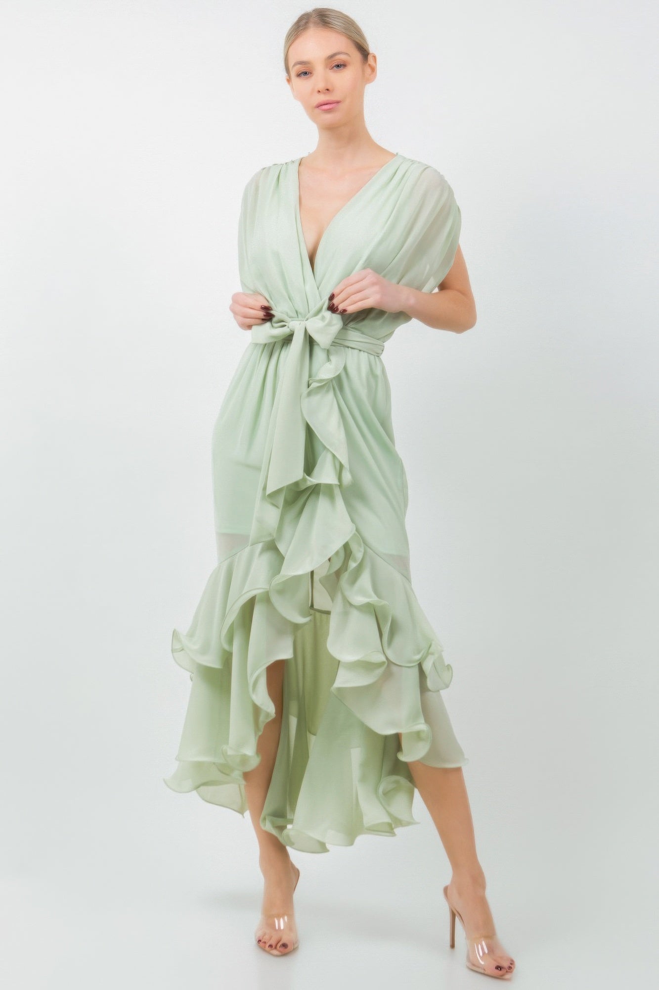 Woman wearing a sage green ruffle midi dress with a tie waist, adding elegance and femininity to her outfit.