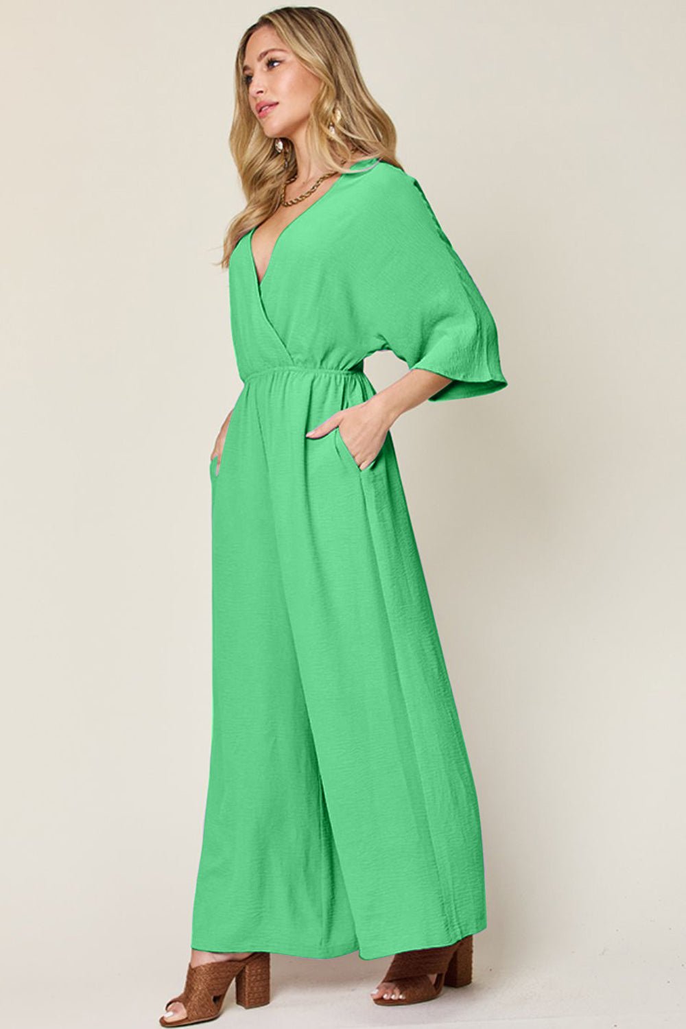 Green surplice wide leg jumpsuit with pockets, perfect for a chic look. Made from 95% polyester and 5% spandex, featuring tied and ruched design.