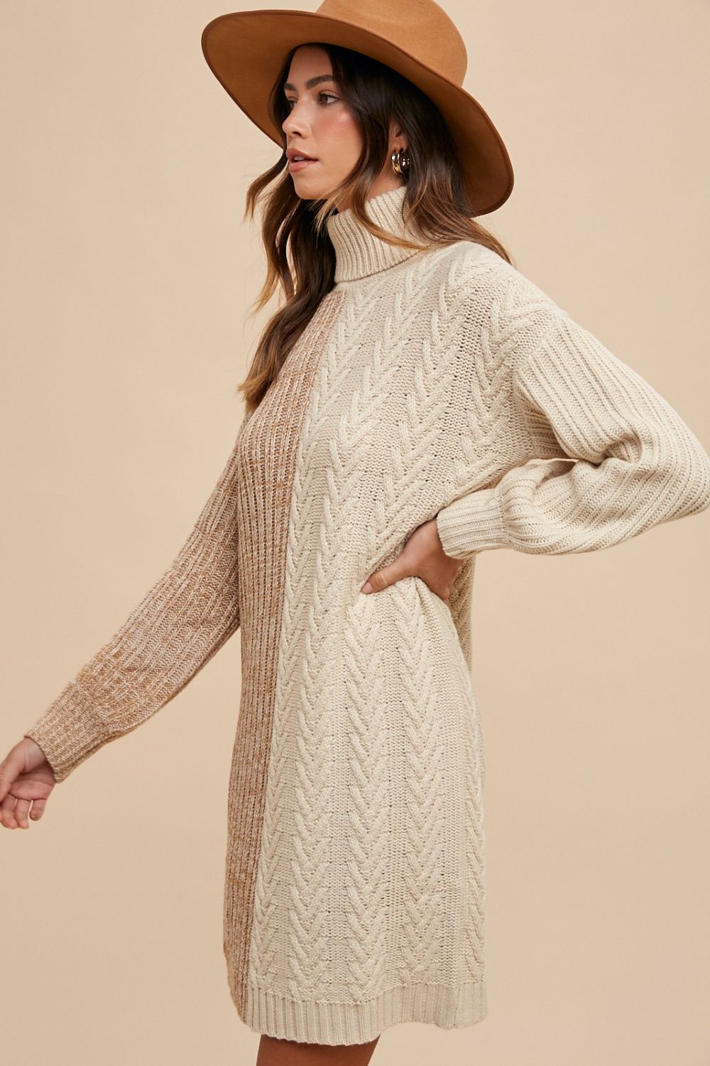 Woman in winter color block turtleneck sweater dress and hat, showcasing cozy ribbed knit style, 100% acrylic fabric, slightly stretchy fit.