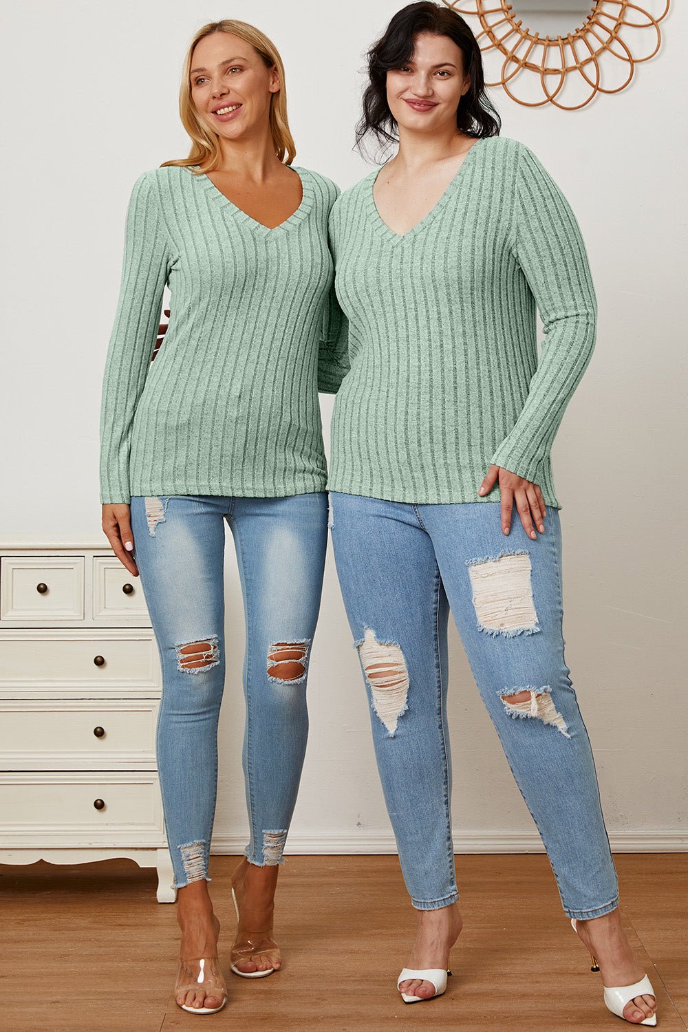 Women wearing Basic Bae Full Size Ribbed V-Neck Long Sleeve T-Shirts with light blue ripped jeans, showcasing casual chic style.