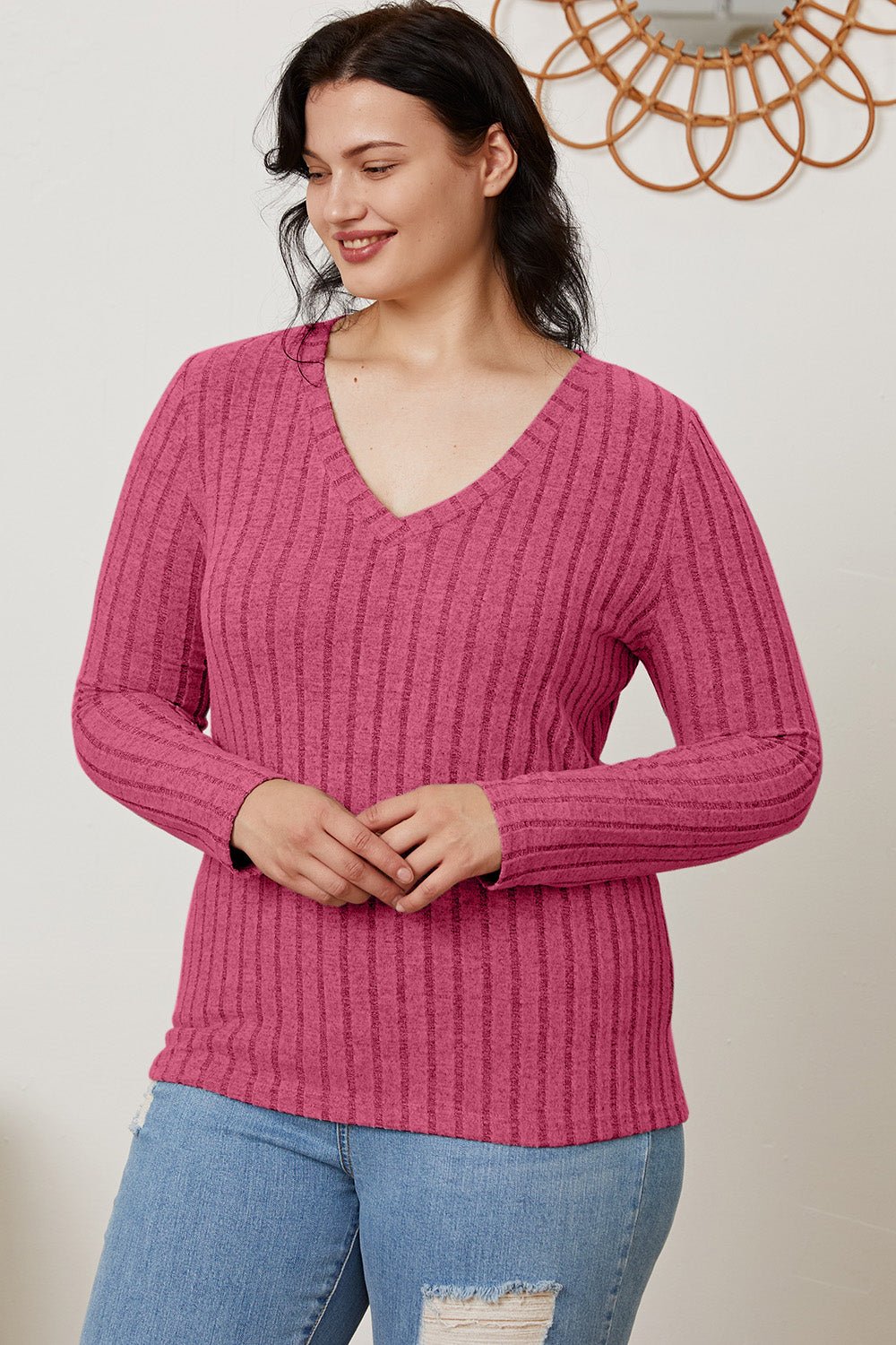 Woman wearing a Basic Bae ribbed V-neck long sleeve T-shirt in pink, paired with blue jeans.