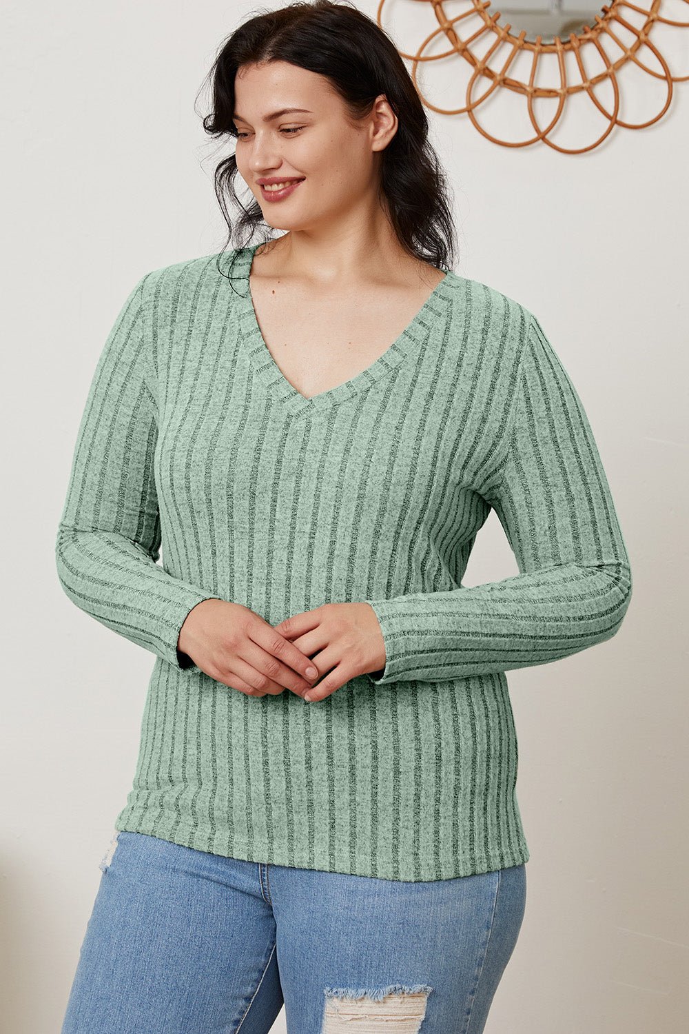 Woman wearing green ribbed V-neck long sleeve T-shirt and ripped jeans, showcasing Basic Bae full-size casual style.