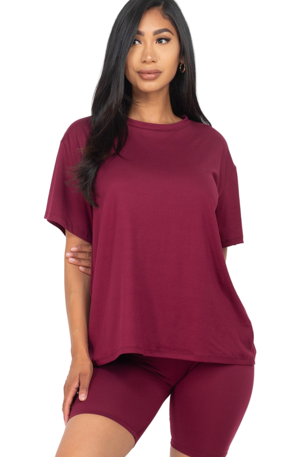 Woman wearing loose fit top and biker shorts set in burgundy, showcasing soft, stretchy fabric ideal for casual and workout wear.