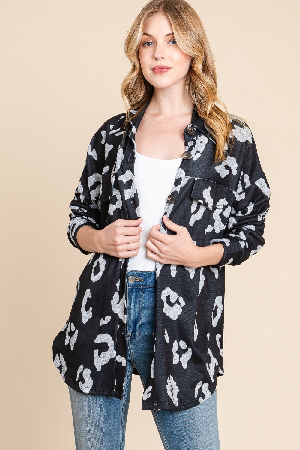 Woman wearing an animal print button-up knit shacket with pockets, made of polyester and spandex, slightly stretchy fabric.