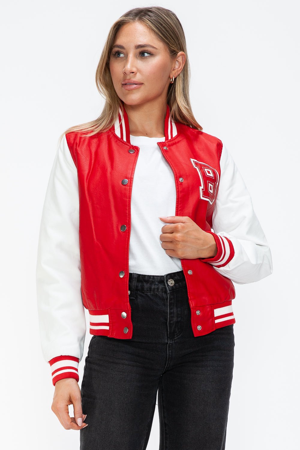 Woman wearing red and white PU leather bomber jacket with snap-down closure and letter detail, styled with jeans and a white top.
