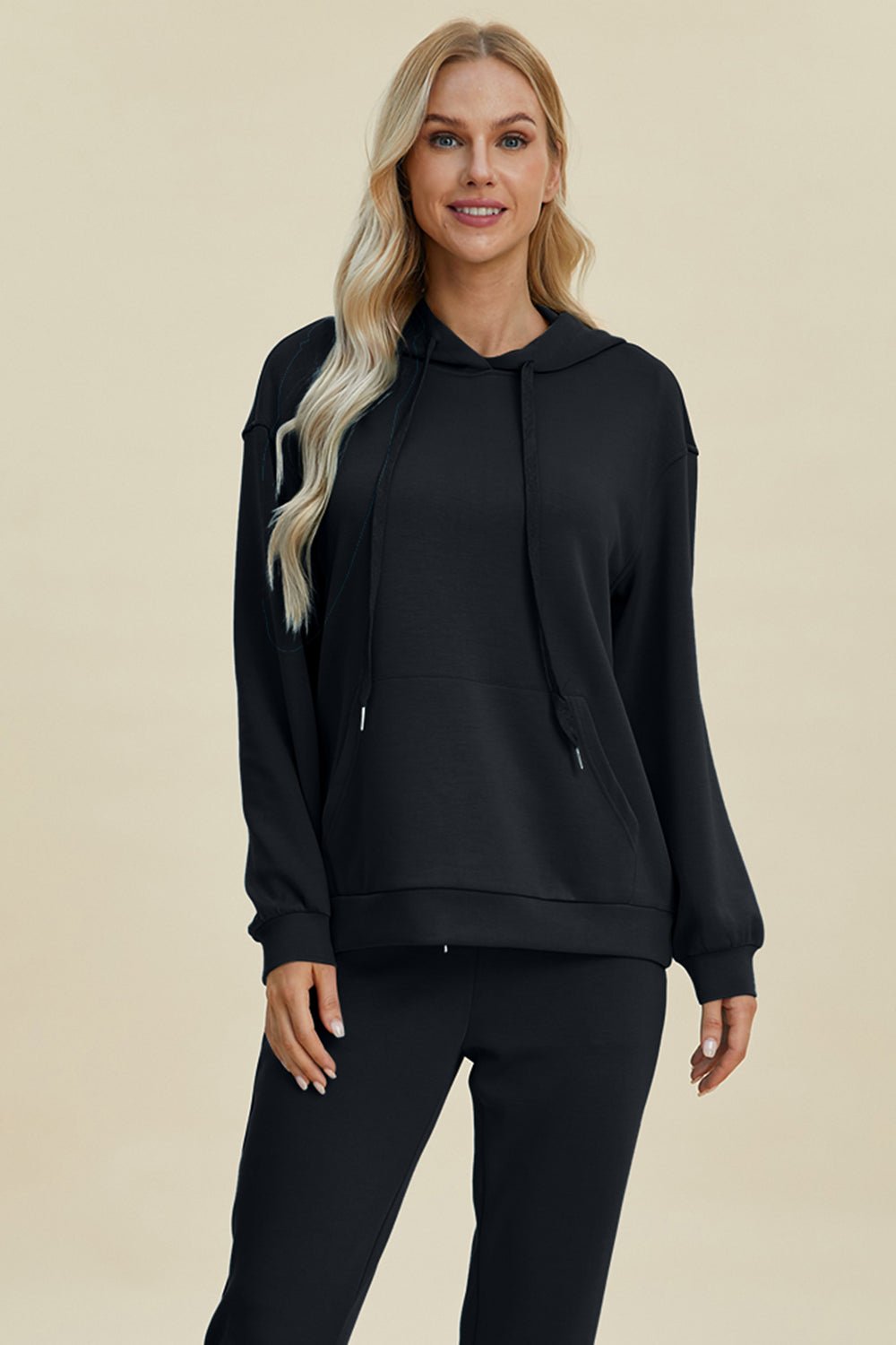 Woman wearing black Basic Bae Air Scuba Long Sleeve Hoodie with drawstring and kangaroo pocket, made of rayon, polyester, and spandex.