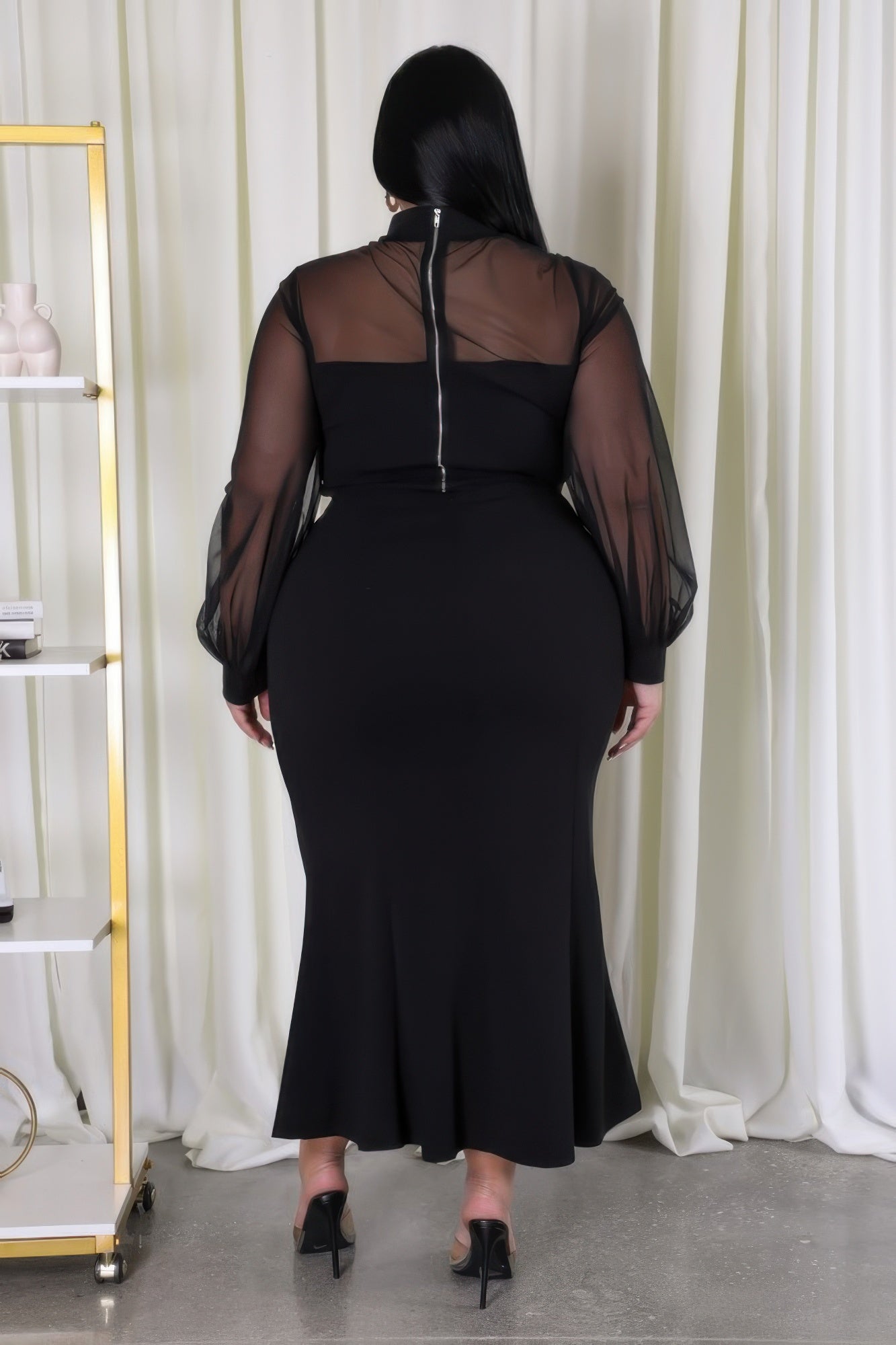 Woman in black Curvy Glam Stretch Skirt Set with mesh accents and zipper closure, showcasing stylish and comfortable fit.