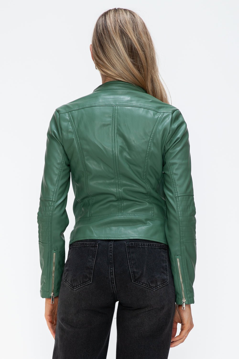 Woman wearing a green faux leather zip-up jacket with drawstring hood, view from the back showing pocket detail and stitching.