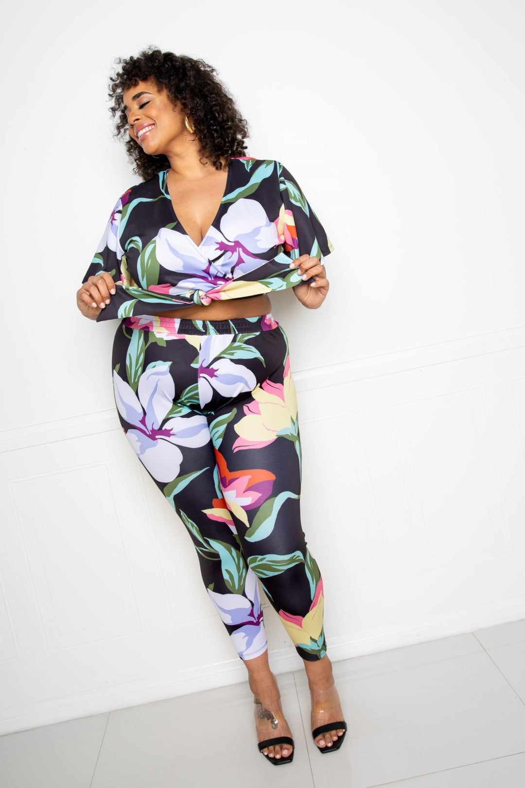 Plus-size model wearing a vibrant Flower Jogger & Top Set in multi/black, showcasing bold floral patterns, perfect for casual wear.