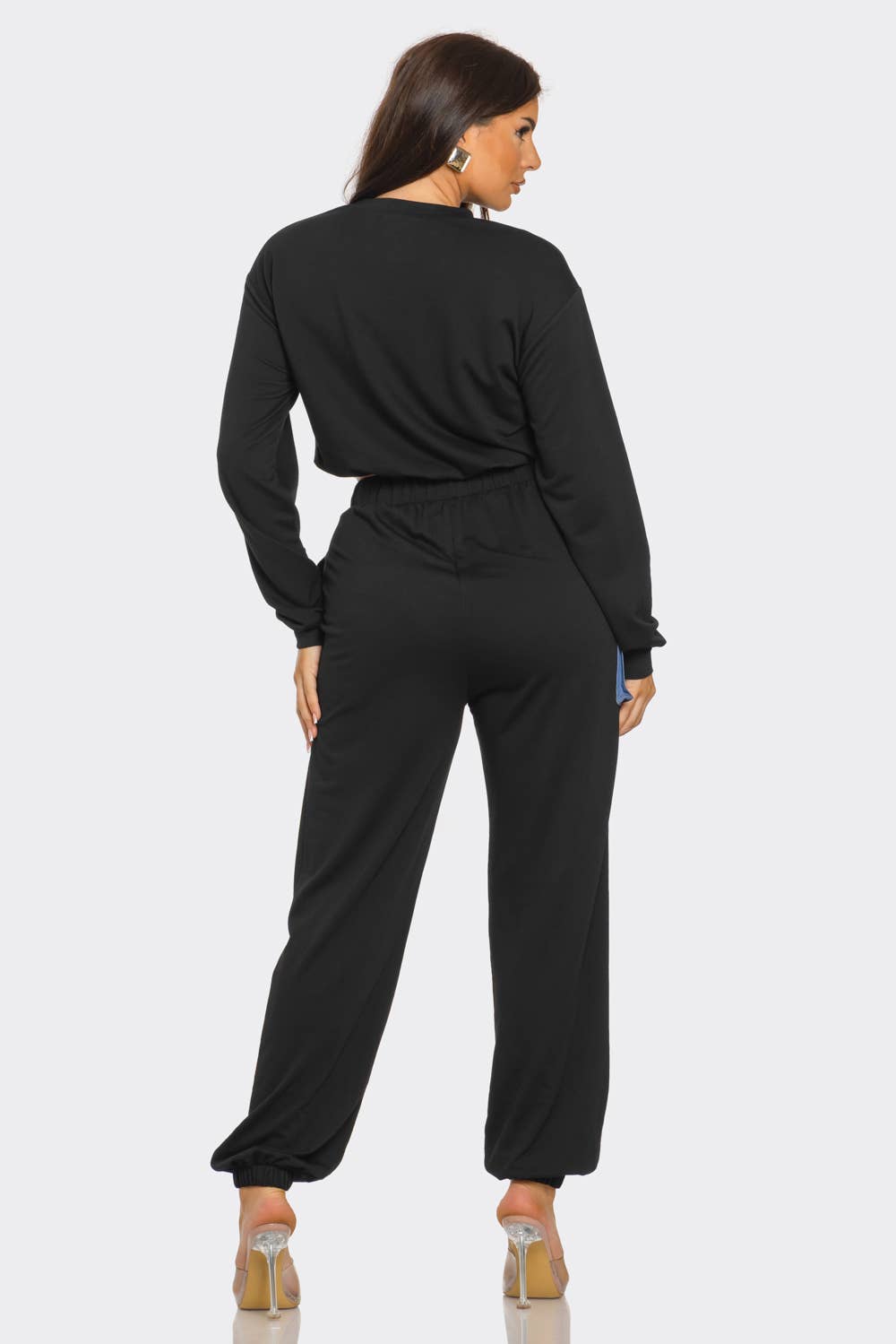 Woman wearing black French Terry set with round neck, long sleeves, and elastic waistband, featuring denim detail and color block design.