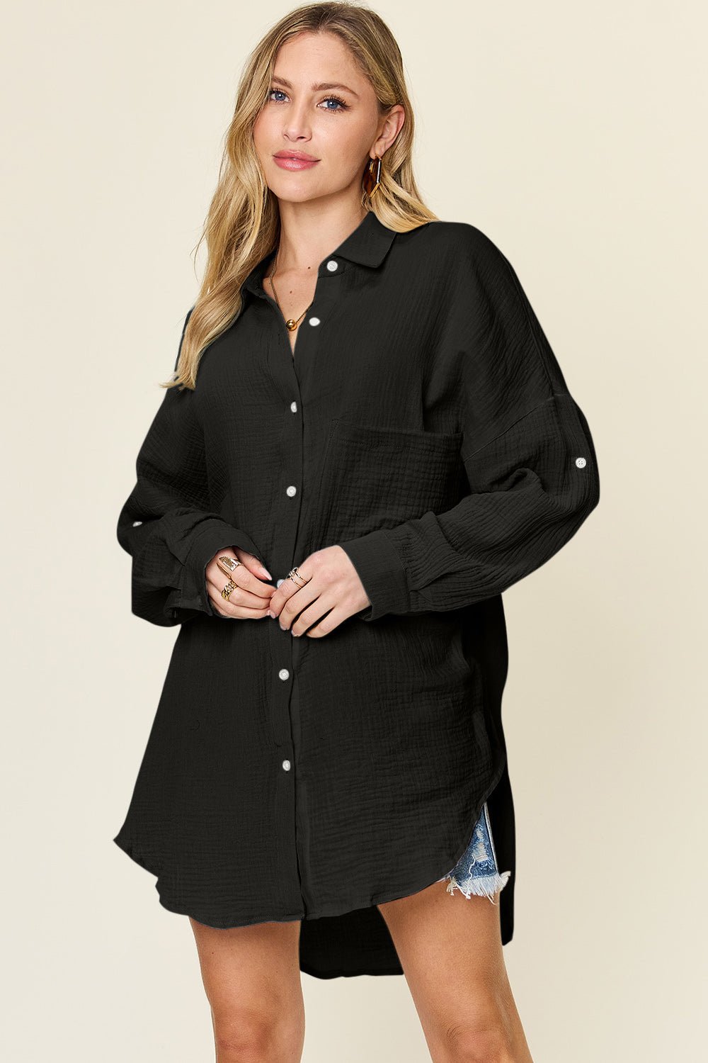 Full size black pocketed button-up shirt with slight stretch, 100% cotton, worn by a model, perfect for casual style.