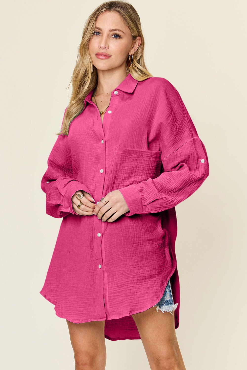 Woman wearing a full size pocketed texture button-up shirt in pink, made of 100% cotton, featuring a slightly stretchy material.