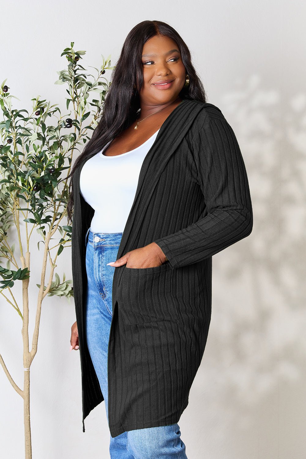Hooded sweater cardigan with pockets, slightly stretchy, opaque fabric, modeled with casual outfit.