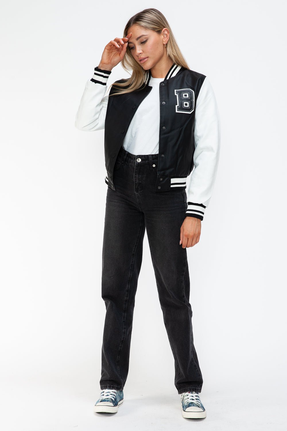 Stylish woman wearing Love PU Leather Contrast Snap Down Bomber Jacket with black and white design and striped cuffs.