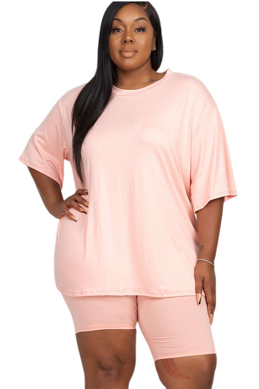 Plus size woman wearing pink loose fit top and biker shorts set, comfortable and breathable casual outfit.