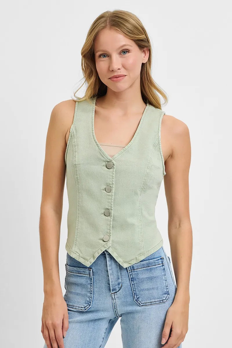 Young woman with blonde hair wearing a sage green sleeveless button-up vest over blue jeans, standing against a white background in a product photo...