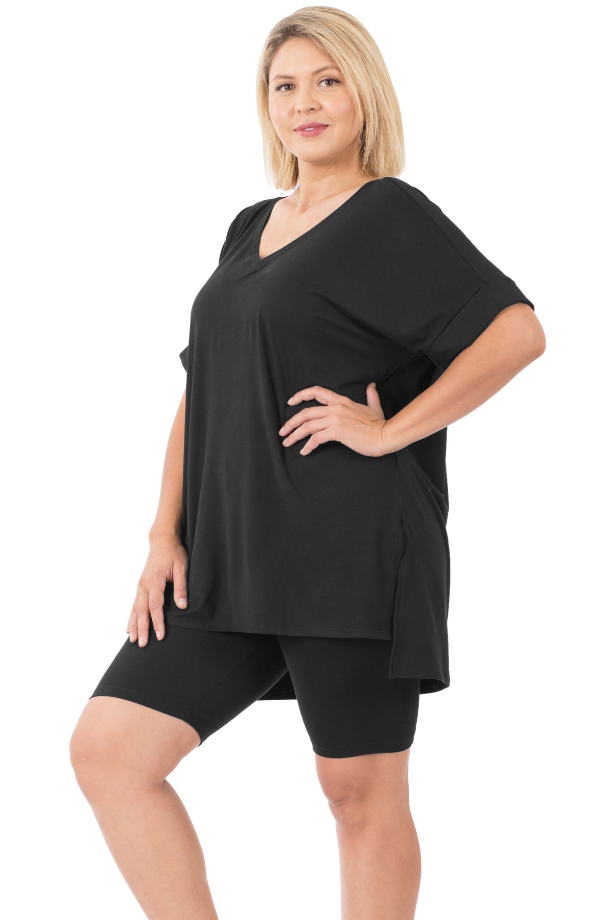 Woman wearing plus size black V-neck top and biker shorts set with hi-low hem, showcasing buttery soft microfiber fabric.