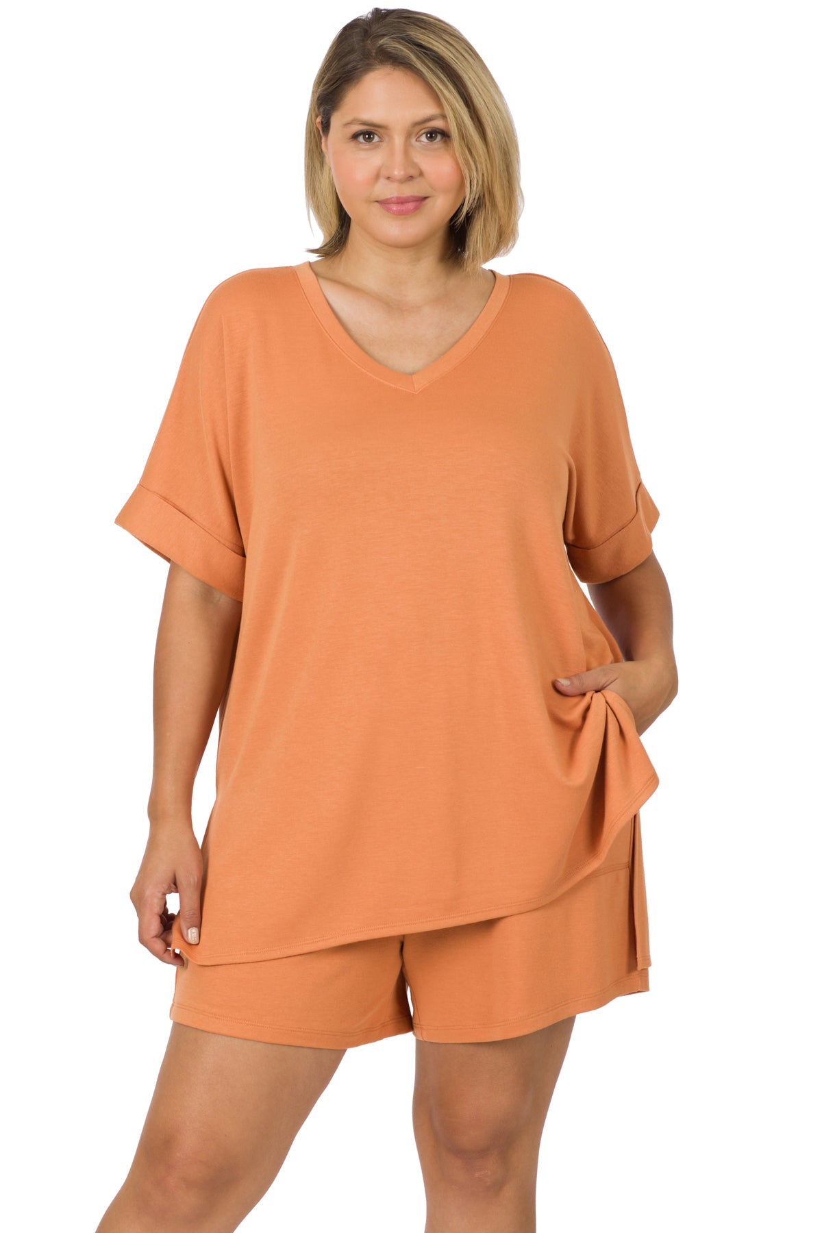 Woman wearing plus size soft French terry loungewear set with V-neck top and drawstring shorts in terracotta color.
