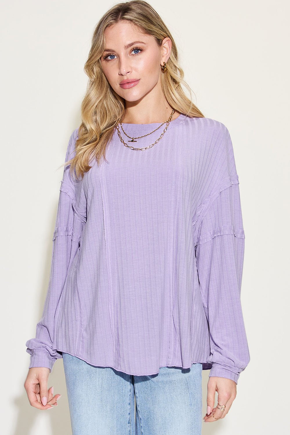 Ribbed round neck long sleeve lavender t-shirt, exposed seam design, worn by model with blonde hair, paired with blue jeans.