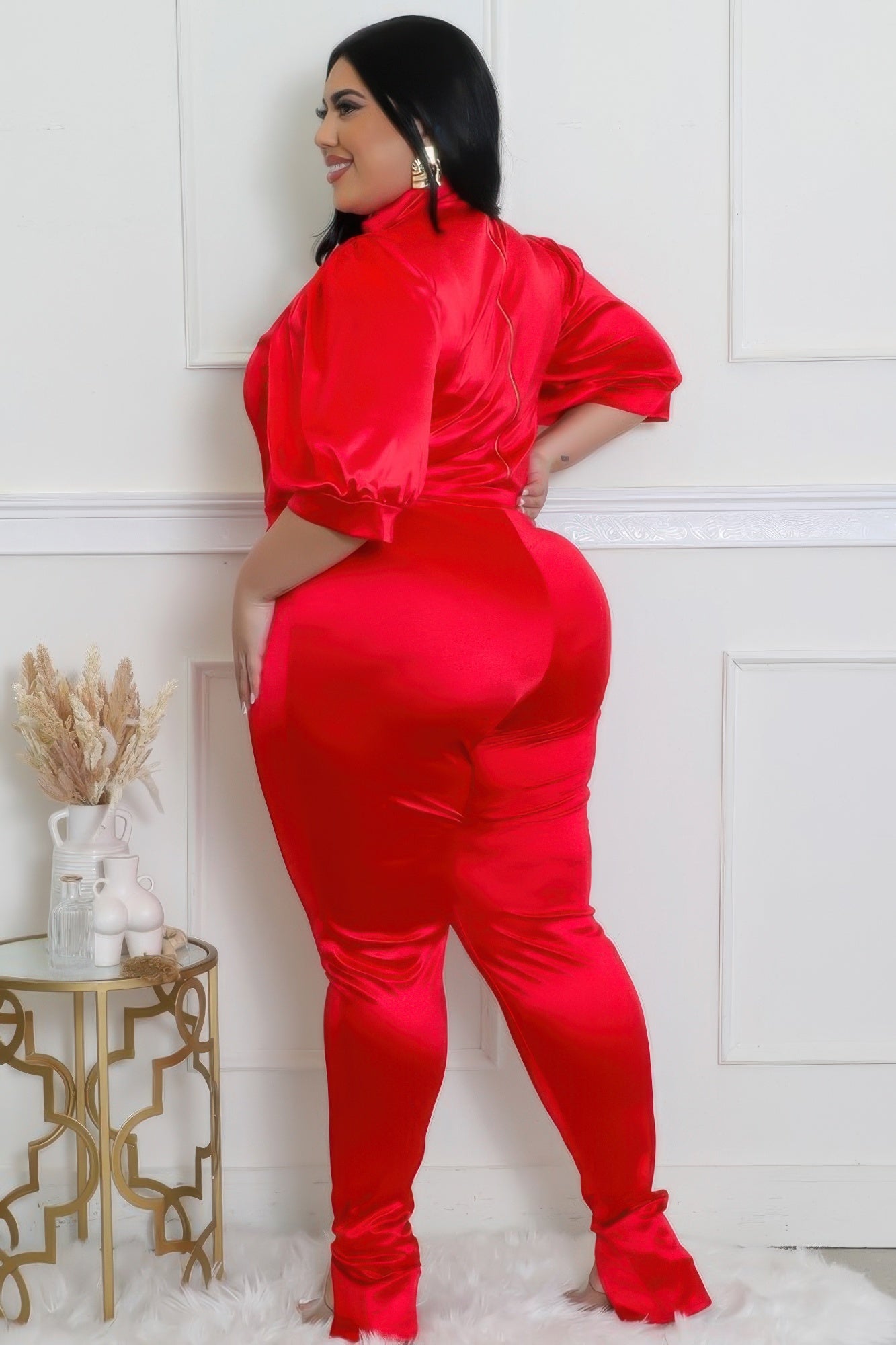 Woman wearing red satin curvy two-piece semi-stretch bodysuit with high-waisted pants, showcasing a luxurious and figure-accentuating style.
