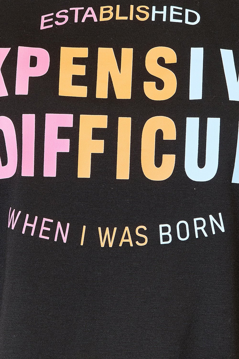 Black slogan graphic T-shirt with colorful text design including "Established", "Expensive", "Difficult", and "When I Was Born".
