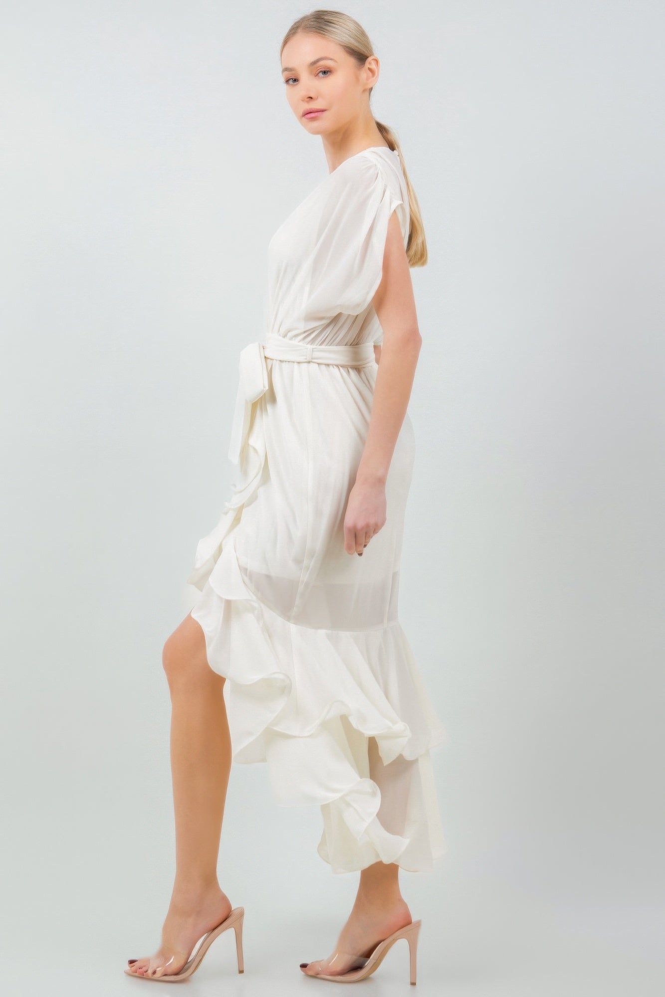 Woman wearing white solid tie waist ruffle midi dress with elegant asymmetrical hem and soft ruffles, side view, stylish fashion