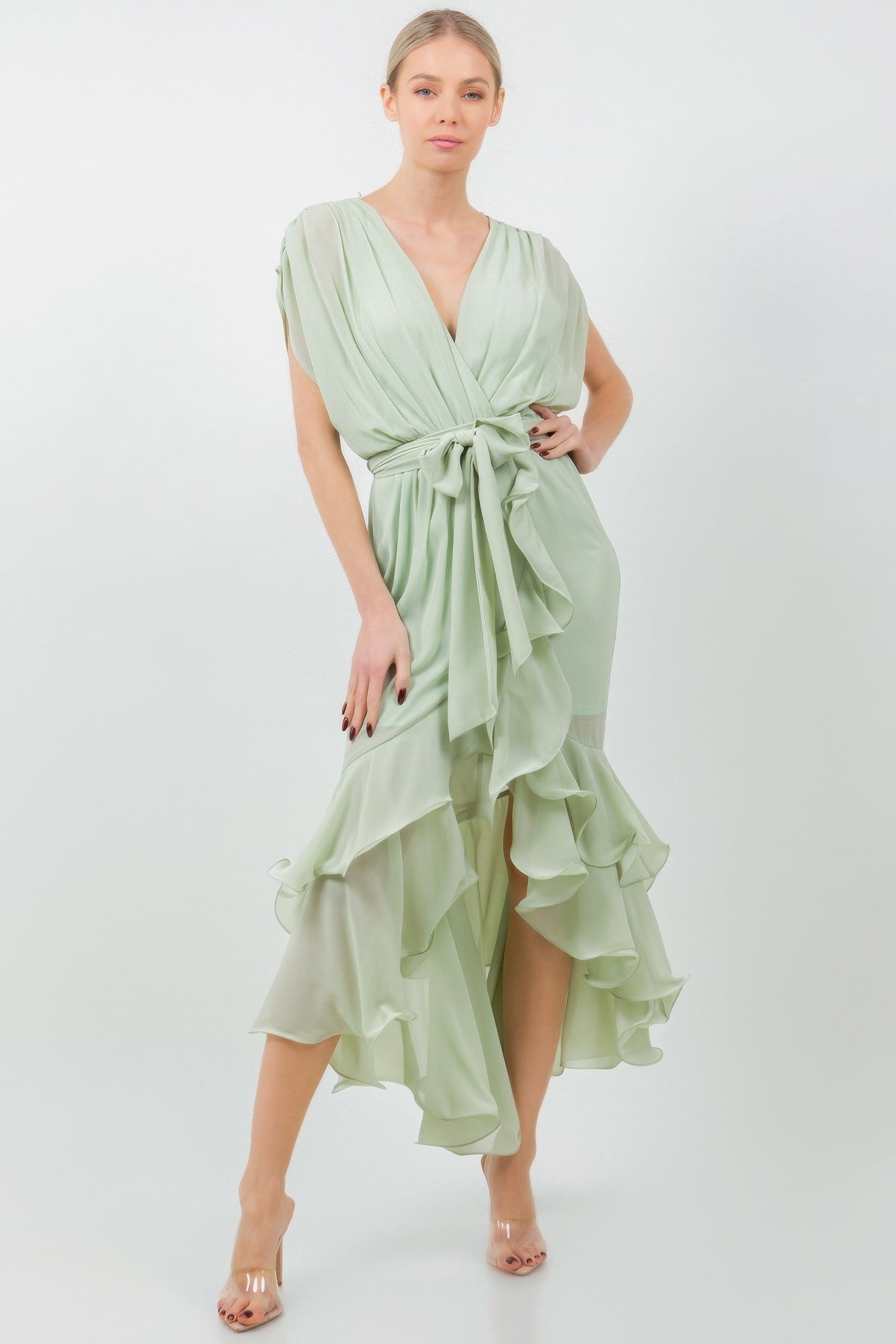 Woman wearing green tie waist ruffle midi dress with elegant design.